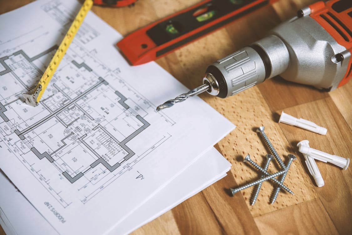 A person drawing a home renovation plan with a heloc calculator, illustrating the use of a HELOC for home improvement.